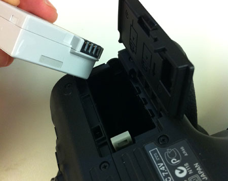 Canon Rebel LP-E8 battery being inserted into camera